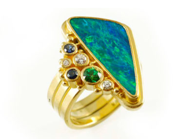 18 and 22 kt yellow gold ring with boulder opal, diamonds, emerald, and sapphire